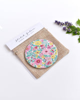 Floral Liberty fabric pocket mirror. Pretty floral Liberty of London fabric covers the back of the small round hand mirror.
The round pocket mirror measures 77mm in diameter and comes with a linen drawstring pouch.
Image shows the pretty pocket mirror sitting on top of the linen pouch.
Handmade by Stitch Galore.