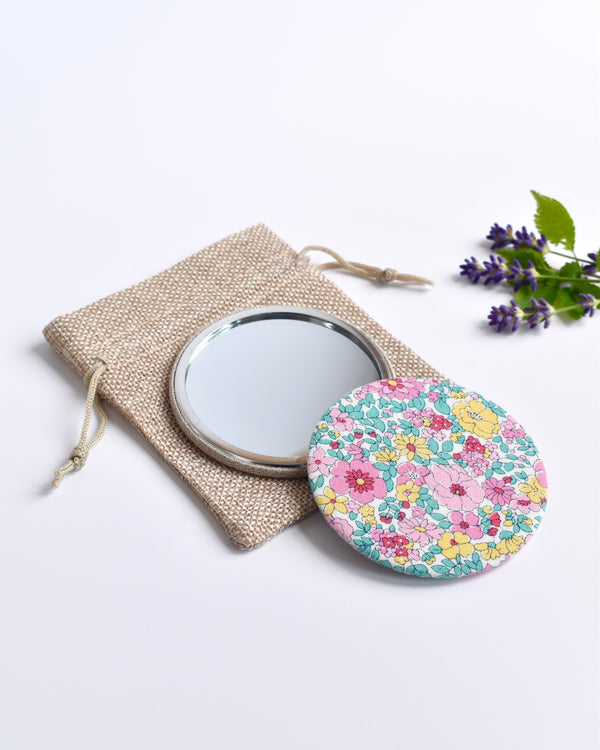 Floral Liberty fabric pocket mirror. Pretty floral Liberty of London fabric covers the back of the small round hand mirror.
The round pocket mirror measures 77mm in diameter and comes with a linen drawstring pouch.
Image shows the pretty pocket mirror sitting on top of the linen pouch.
Handmade by Stitch Galore.
